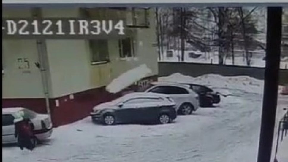 на фото момент падения снега на припаркованный автомобиль. фото администрации Северодвинска